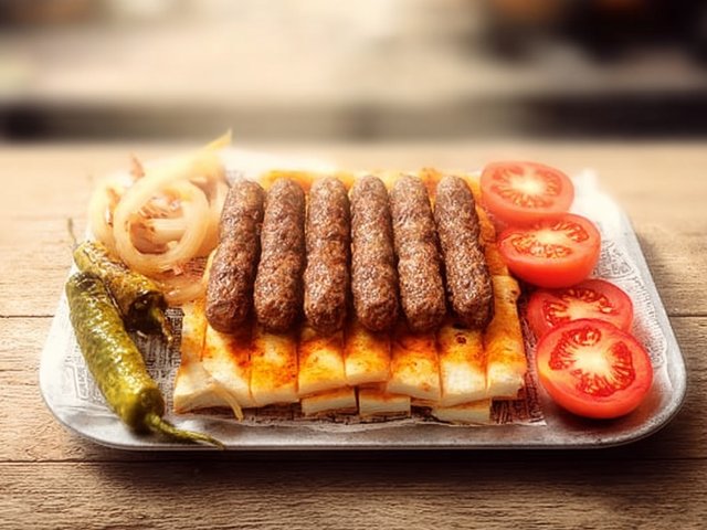 Ödemiş köftesi · tereyağında biberli ekmek dilimleri üzerinde silindirik köfteler